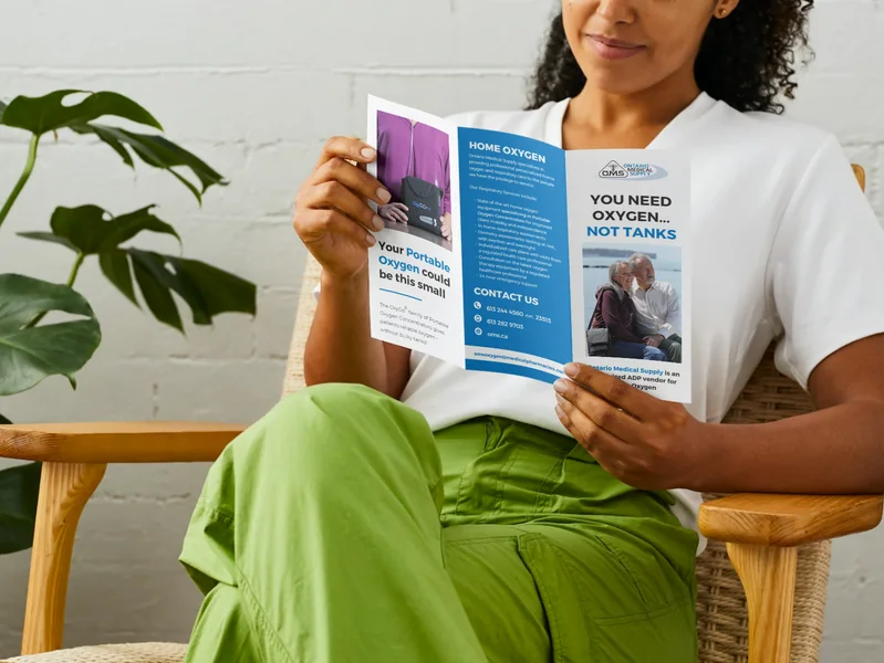 Trifold brochure held open by a reader